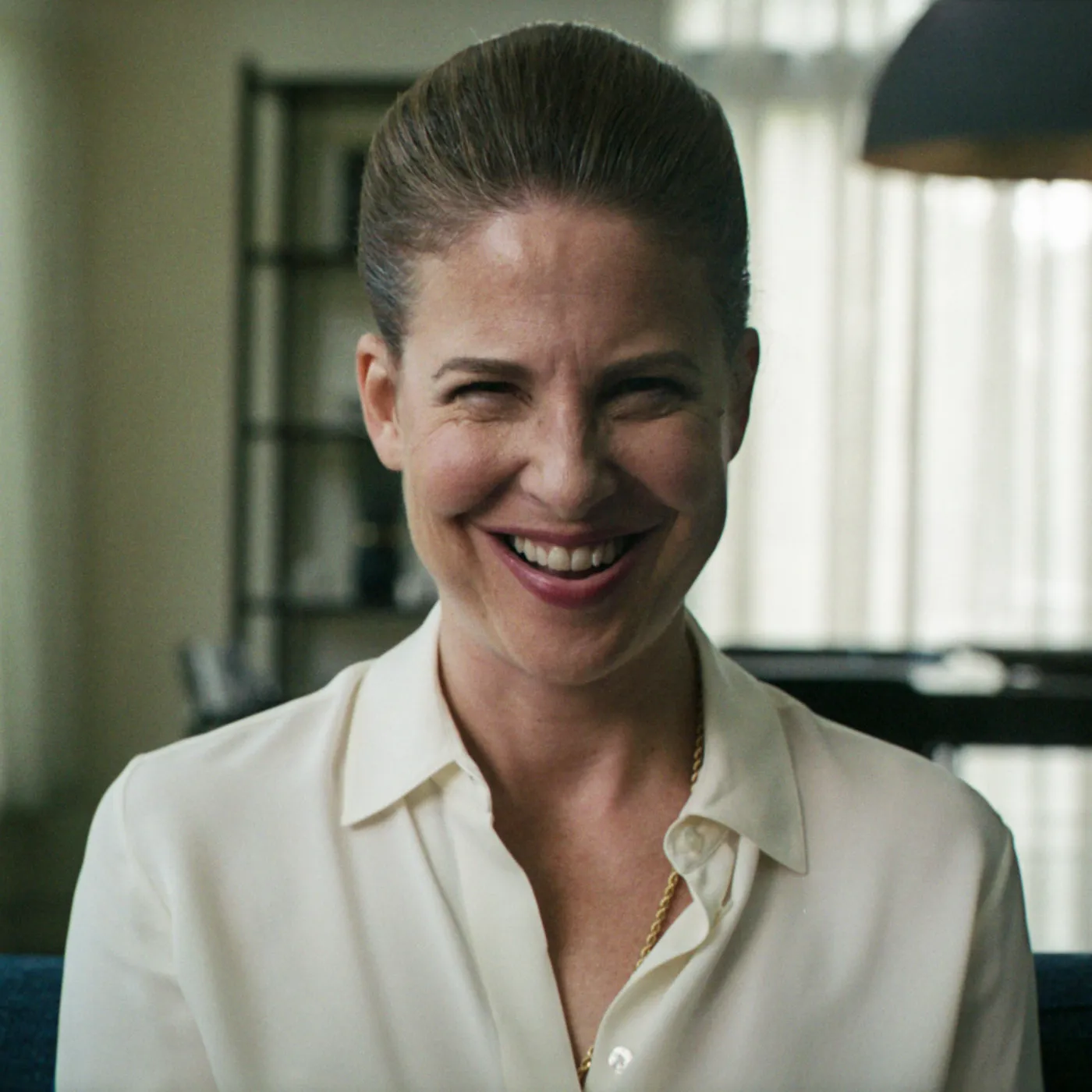 A woman with grey hair creepily smiling to the camera