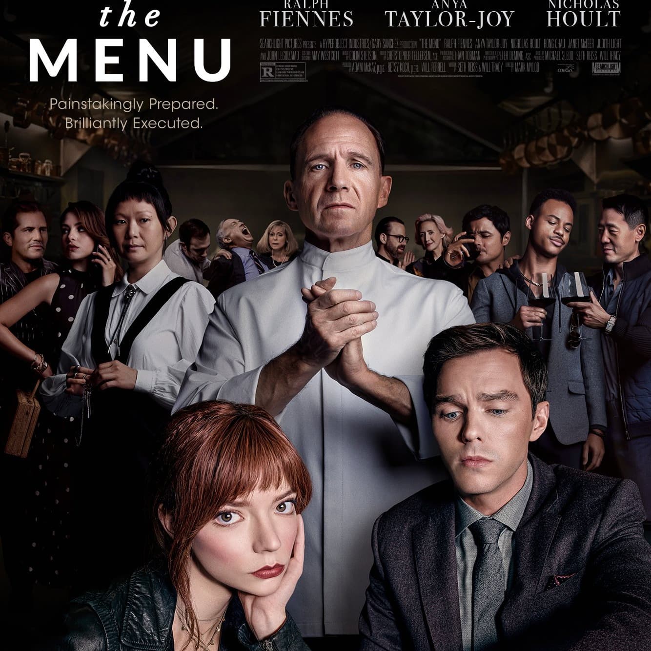 A chef serving food to two dinner guests